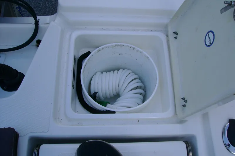 Slide: The Image of Storage compartment with coiled hose on 2022 NauticStar 227 XTS boat. - 10