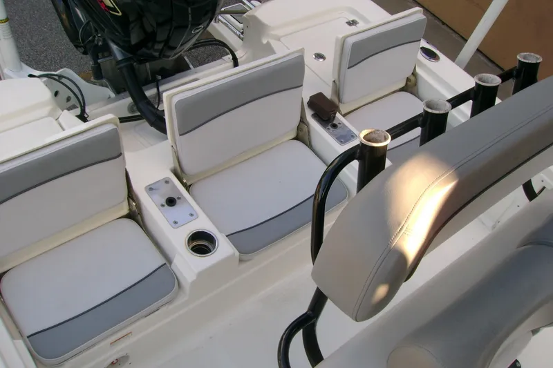 Slide: The Image of 2022 NauticStar 227 XTS boat interior with cushioned seating and rod holders. - 16