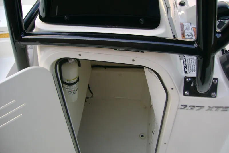 Slide: The Image of 2022 NauticStar 227 XTS boat storage compartment with fire extinguisher. - 17