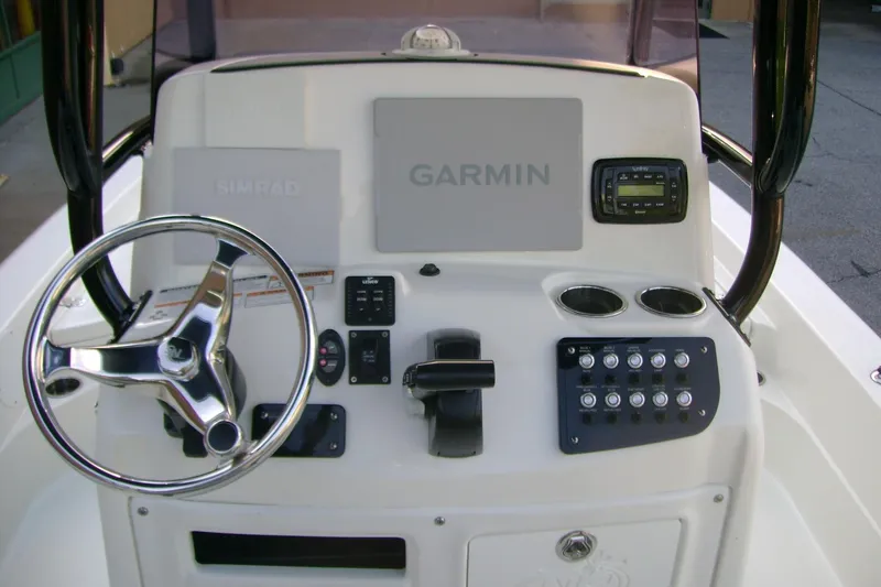 Slide: The Image of 2022 NauticStar 227 XTS boat console with steering wheel, Garmin, and Simrad displays. - 4
