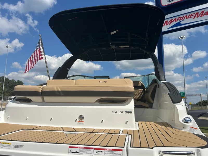 Slide: The Image of The image shows the rear of a Sea Ray SLX 260 boat with beige upholstery and a black sunshade. - 44