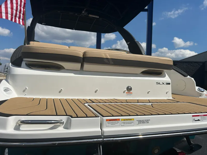 Slide: The Image of The image shows the rear of a Sea Ray SLX 260 boat with beige upholstery and teak decking. - 45
