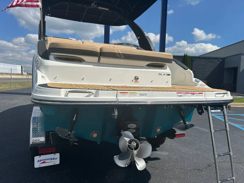 Slide: The Image of The image shows the rear of a 2027 Sea Ray SLX 260 boat with a swim platform and ladder. - 46