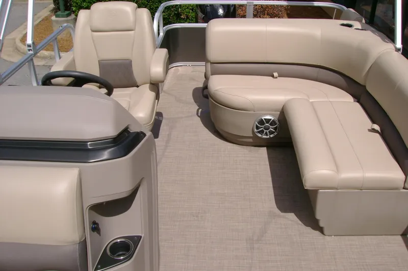 Slide: The Image of 2025 Sun Tracker Party Barge 18 DLX interior with beige seating and steering console. - 6