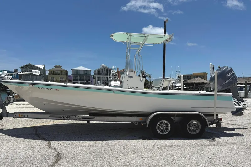The Image of 2006 BlackJack 224 boat on trailer, dockside, under clear blue sky. - 0
