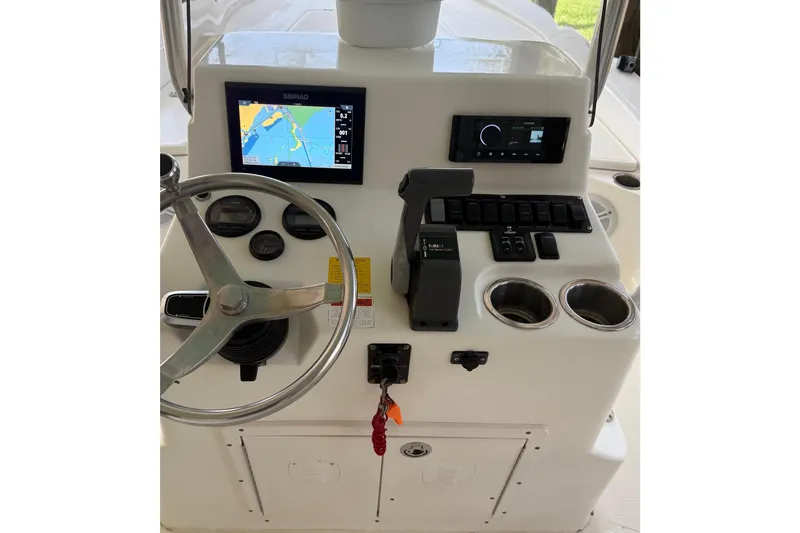 Slide: The Image of Console of a 2006 BlackJack 224 boat with steering wheel and navigation system. - 10
