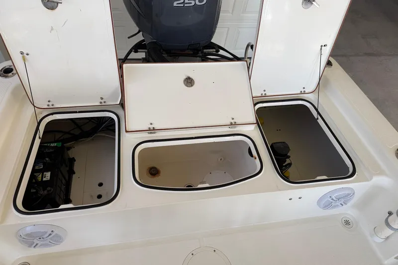 Slide: The Image of Open compartments on a 2006 BlackJack 224 boat, revealing storage and engine area. - 17