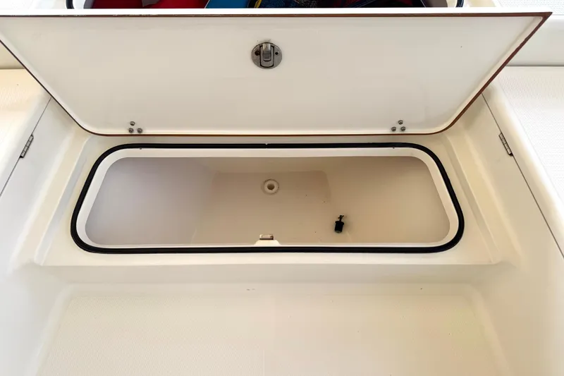 Slide: The Image of Open storage compartment on a 2006 BlackJack 224 boat, featuring a secure latch. - 18