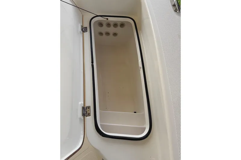 Slide: The Image of Open storage compartment on a 2006 BlackJack 224 boat, featuring a white interior. - 20