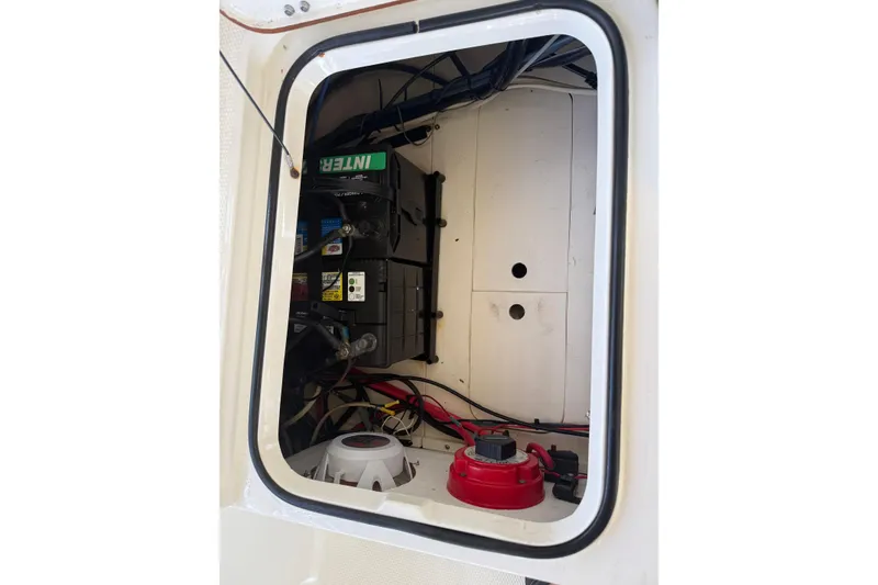 Slide: The Image of Electrical compartment of a 2006 BlackJack 224 boat, featuring battery and wiring. - 27