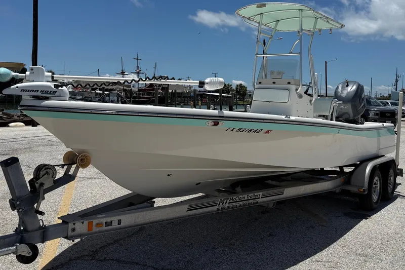 Slide: The Image of 2006 BlackJack 224 boat on trailer, equipped with Minn Kota motor, parked in marina. - 3