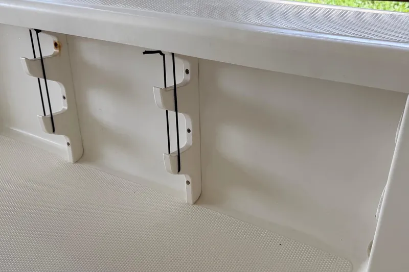 Slide: The Image of Interior view of a 2006 BlackJack 224 boat, featuring rod holders and a clean white finish. - 30