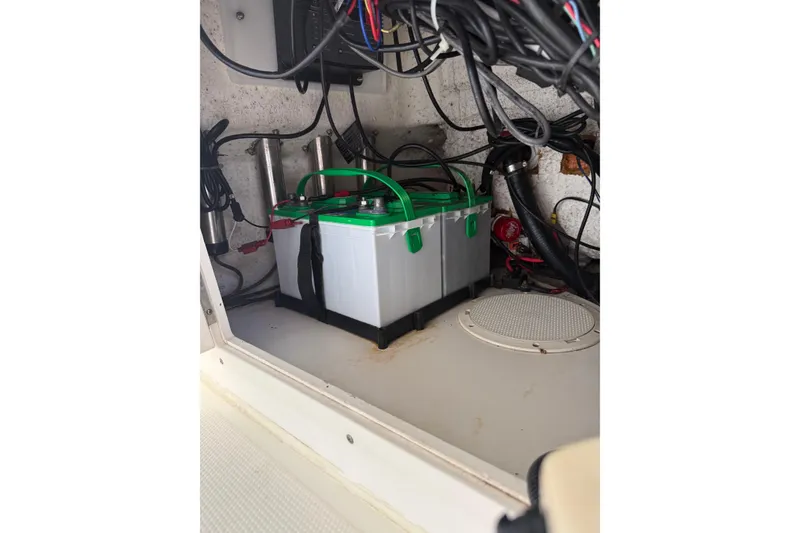 Slide: The Image of Battery compartment of a 2006 BlackJack 224 boat, featuring wiring and a secured battery. - 31