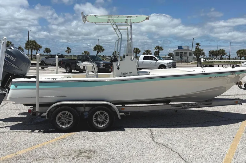 Slide: The Image of 2006 BlackJack 224 boat on trailer, parked in sunny marina with palm trees. - 5