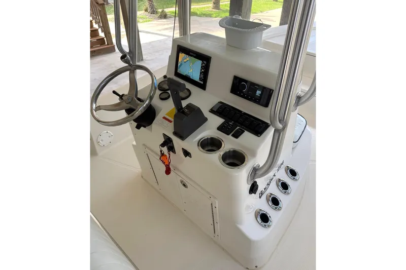 Slide: The Image of Center console of a 2006 BlackJack 224 boat with steering wheel and navigation controls. - 9