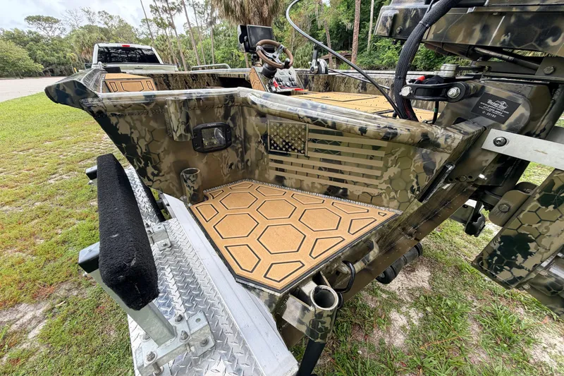 Slide: The Image of Camouflage-patterned Prodigy 1854 boat, 2024 model, with hexagonal deck design and American flag detail. - 15