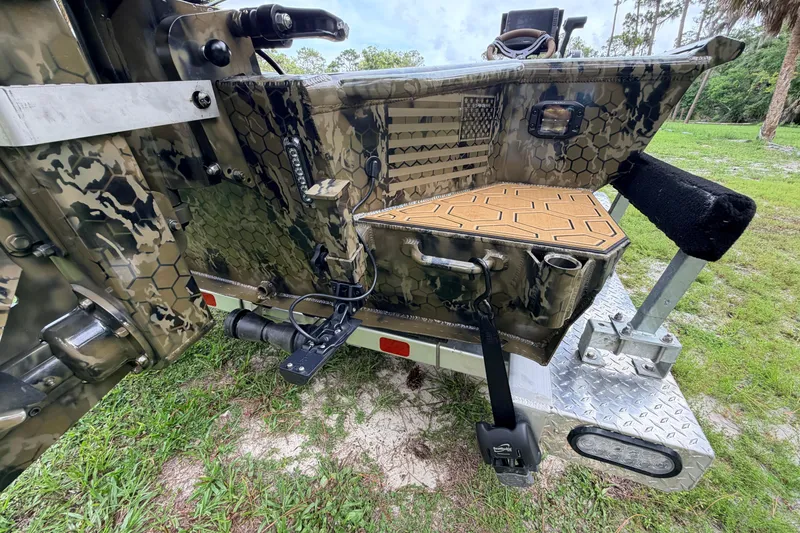 Slide: The Image of Camouflage-patterned Prodigy 1854 boat, 2024 model, on trailer with grass background. - 18