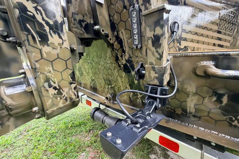 Slide: The Image of Camouflage-patterned Prodigy 1854 boat detail, showcasing 2024 model's rugged design and wiring. - 19