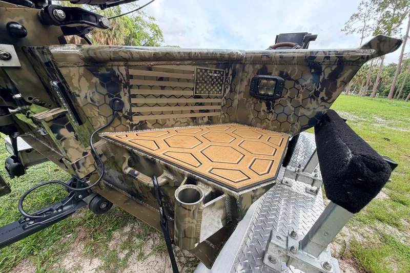 Slide: The Image of Camouflage-patterned Prodigy 1854 boat, 2024 model, with hexagonal deck design and American flag detail. - 21