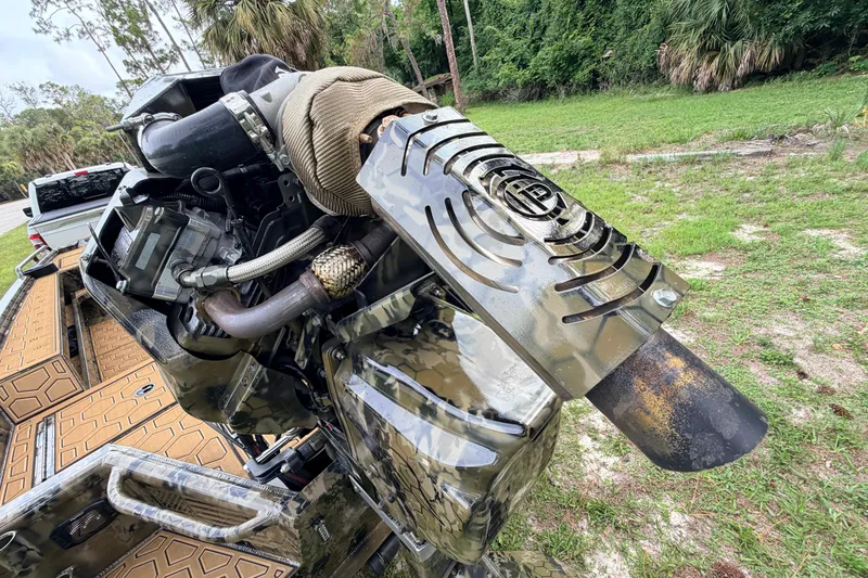Slide: The Image of Outdoor view of a 2024 Prodigy 1854 boat engine with camo design and exhaust system. - 25
