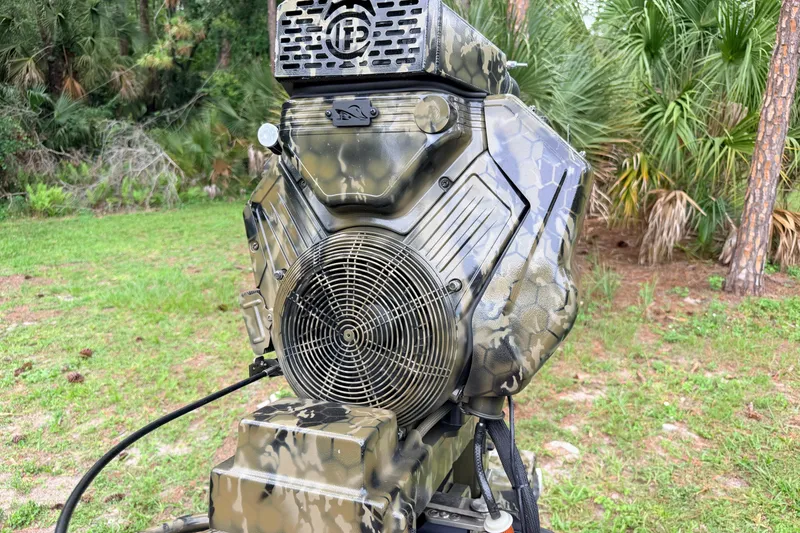 Slide: The Image of Camouflage-patterned Prodigy 1854 engine, 2024 model, in a lush outdoor setting. - 28