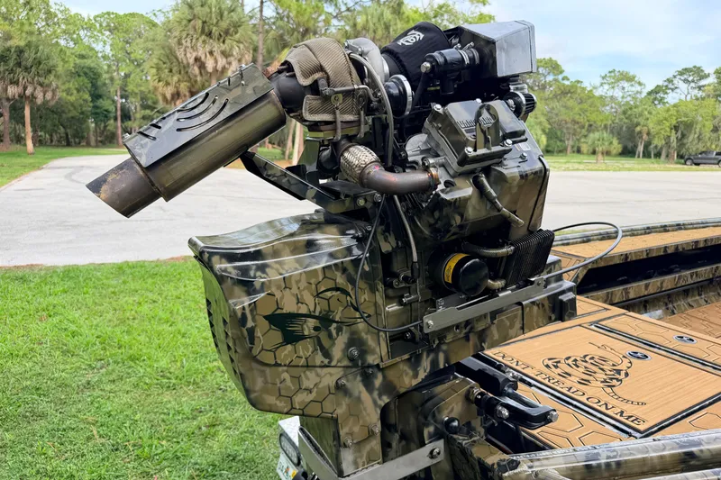 Slide: The Image of 2024 Prodigy 1854 boat engine with camouflage design, parked outdoors. - 29