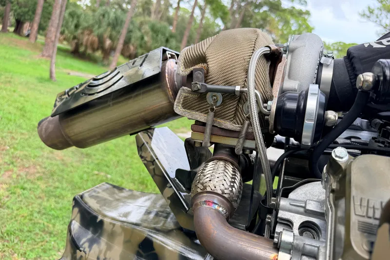 Slide: The Image of Close-up of Prodigy 1854 engine exhaust system, 2024 model, in a natural outdoor setting. - 31