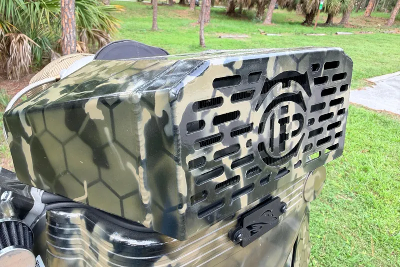 Slide: The Image of Camouflage-patterned Prodigy 1854 engine cover, 2024 model, in a natural outdoor setting. - 32