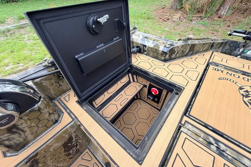 Slide: The Image of Open hatch on 2024 Prodigy 1854 boat, revealing storage compartment with hexagonal pattern. - 53