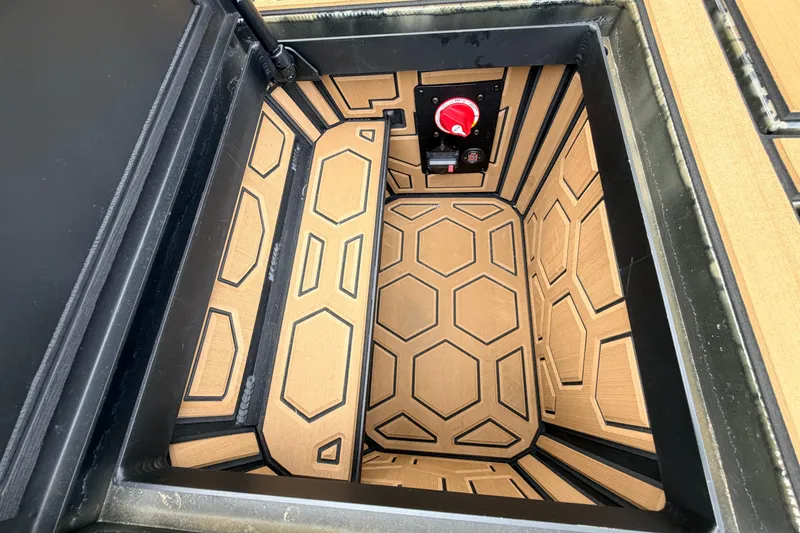 Slide: The Image of Storage compartment of 2024 Prodigy 1854 boat with hexagonal pattern and red switch. - 54