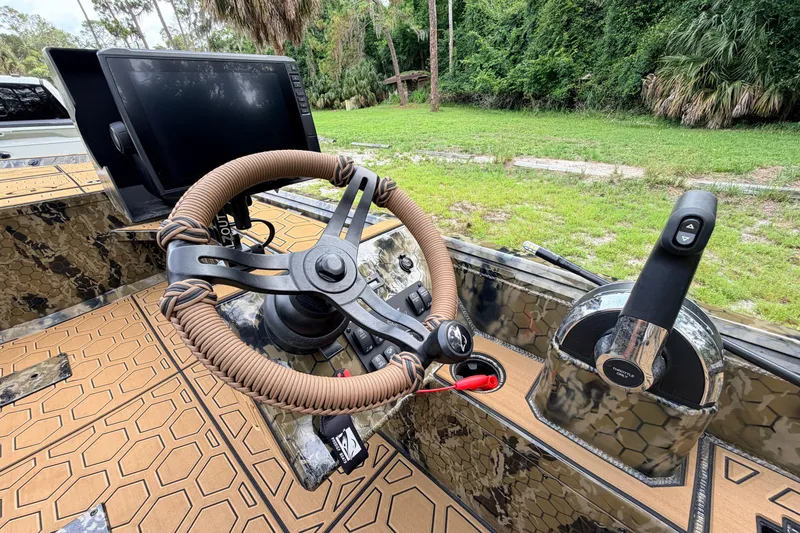Slide: The Image of Steering console of 2024 Prodigy 1854 boat with camouflage design and advanced controls. - 58