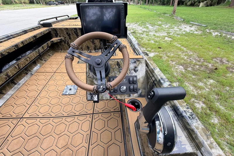 Slide: The Image of Steering console of 2024 Prodigy 1854 boat with advanced controls and camo design. - 59