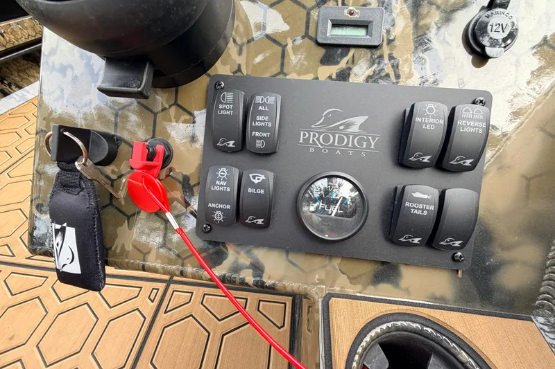 Slide: The Image of Control panel of a 2024 Prodigy 1854 boat with various switches and key. - 60