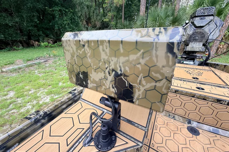 Slide: The Image of 2024 Prodigy 1854 boat with camouflage design and hexagonal patterns in a wooded area. - 61