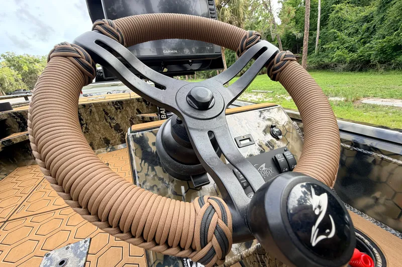 Slide: The Image of Steering wheel of 2024 Prodigy 1854 boat with camo design and advanced controls. - 62