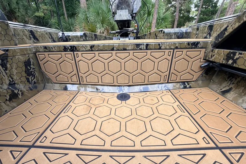 Slide: The Image of 2024 Prodigy 1854 boat interior with hexagonal patterned flooring and camo design. - 65