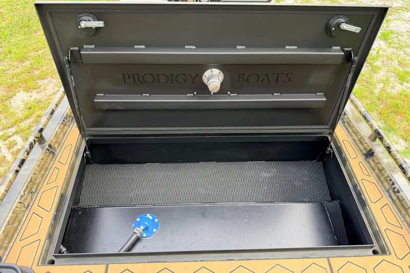 Slide: The Image of Open storage compartment of 2024 Prodigy 1854 boat, showcasing interior design and branding. - 70