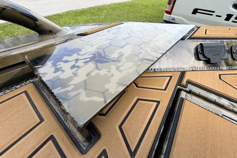 Slide: The Image of 2024 Prodigy 1854 boat with camouflage pattern and textured deck, parked near a Ford F-150. - 75