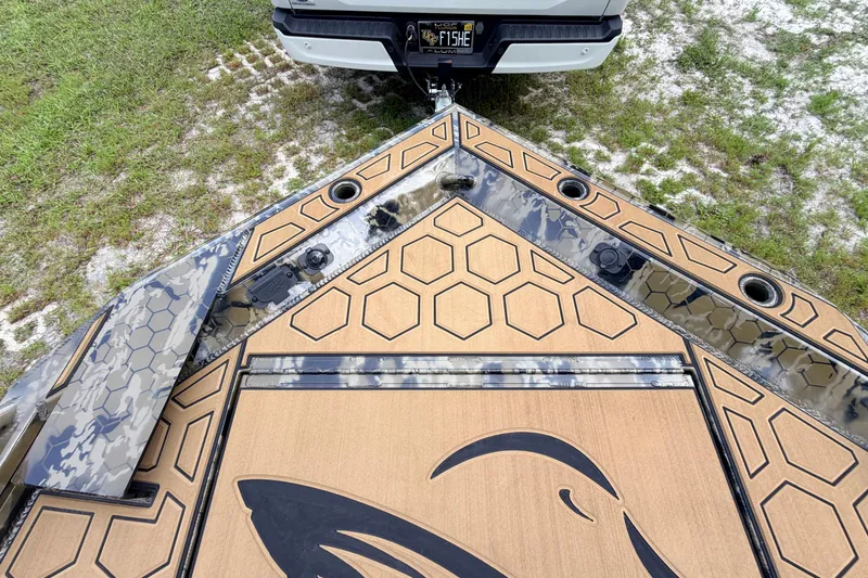 Slide: The Image of 2024 Prodigy 1854 boat with hexagonal pattern deck, camo accents, and fish logo. - 76