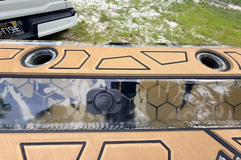Slide: The Image of Boat deck with geometric design, featuring rod holders and a power outlet. Prodigy 1854, 2024 model. - 78