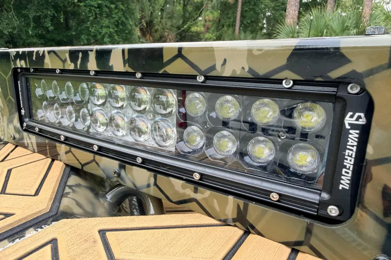 Slide: The Image of LED light bar on 2024 Prodigy 1854 boat with camo design, outdoors. - 81