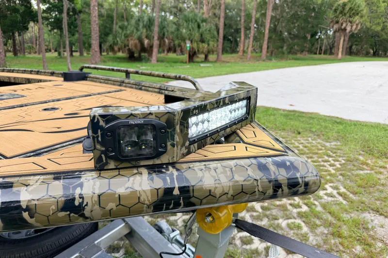 Slide: The Image of Camouflage-patterned Prodigy 1854 boat with LED light bar, 2024 model, in a wooded area. - 82