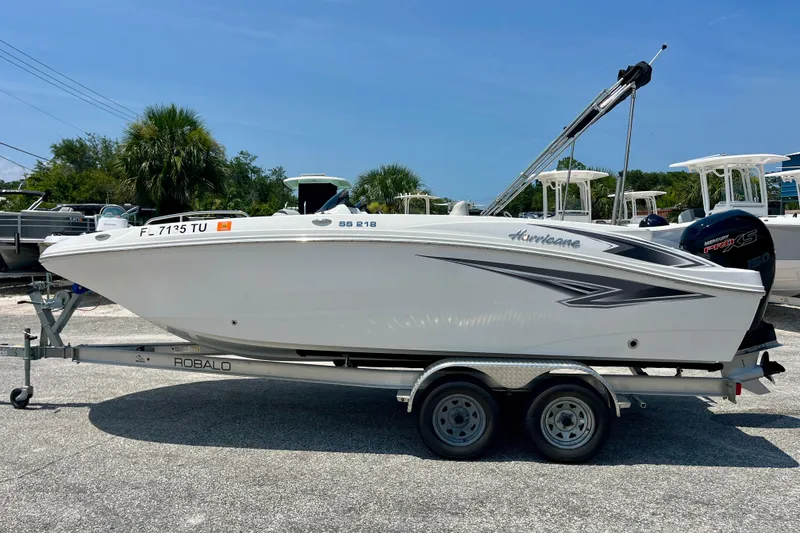 Slide: The Image of 2024 Hurricane Sundeck Sport 218 OB boat on trailer, parked outdoors. - 2