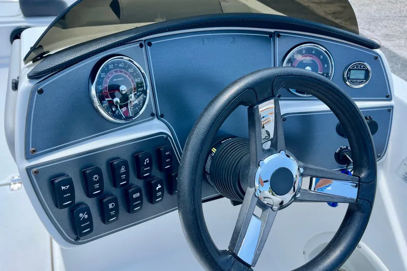 Slide: The Image of Dashboard of 2024 Hurricane Sundeck Sport 218 OB with steering wheel and controls. - 10