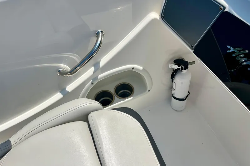 Slide: The Image of 2024 Hurricane Sundeck Sport 218 OB interior with seat, cup holders, and fire extinguisher. - 13