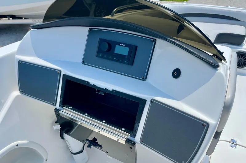 Slide: The Image of 2024 Hurricane Sundeck Sport 218 OB dashboard with stereo system and storage compartment. - 12