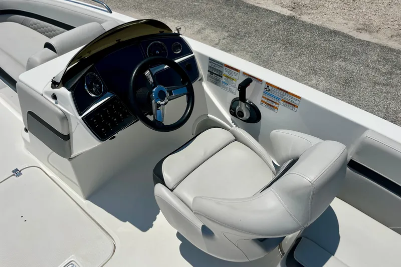 Slide: The Image of 2024 Hurricane Sundeck Sport 218 OB boat cockpit with steering wheel and captain's chair. - 9