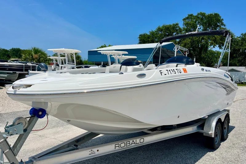 The Image of 2024 Hurricane Sundeck Sport 218 OB boat on trailer, parked outdoors under clear sky. - 1
