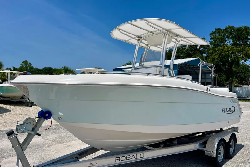 The Image of 2016 Robalo R222 Center Console boat on trailer under clear blue sky. - 1