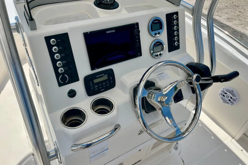 Slide: The Image of 2016 Robalo R222 Center Console boat dashboard with steering wheel and navigation controls. - 10